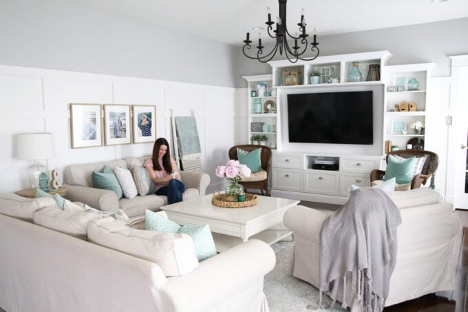 Woman sitting on a couch in a living room looking at her phone