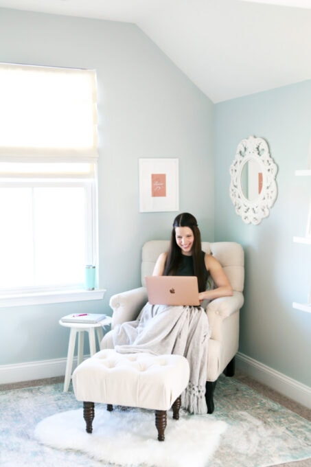 woman sitting in a chair looking at her laptop