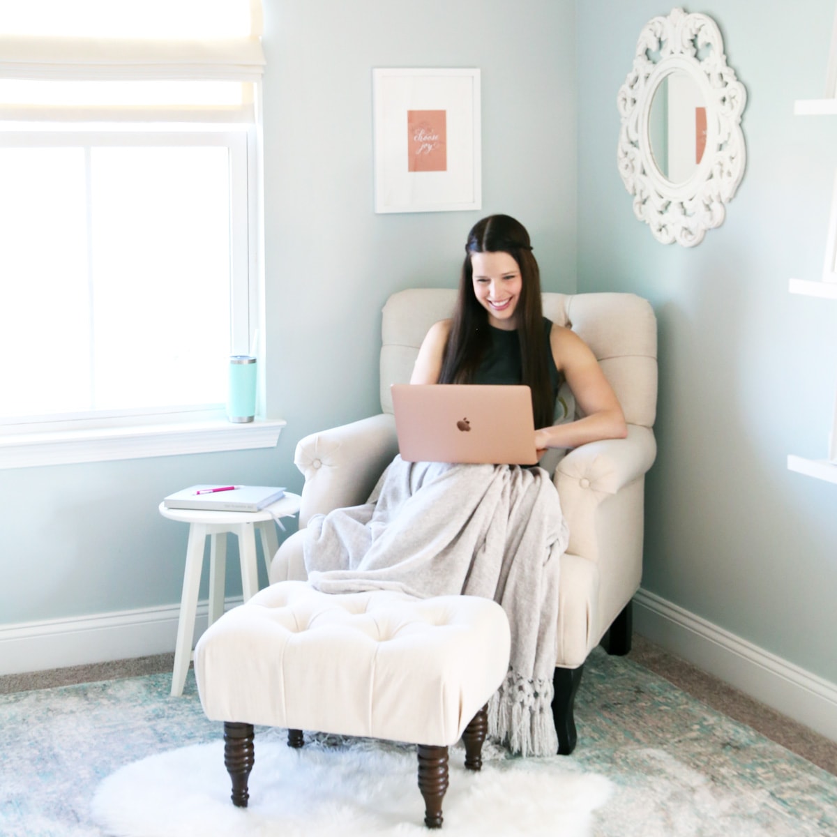 Woman sitting in office chair, managing sinking funds savings account spreadsheet on her computer