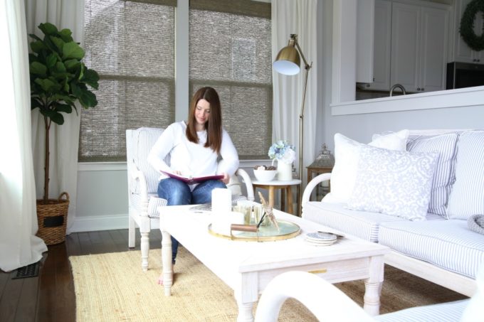 woman in a white shirt sitting in a chair, looking at a planner