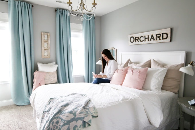 Woman Sitting on Bed in Beautiful Bedroom