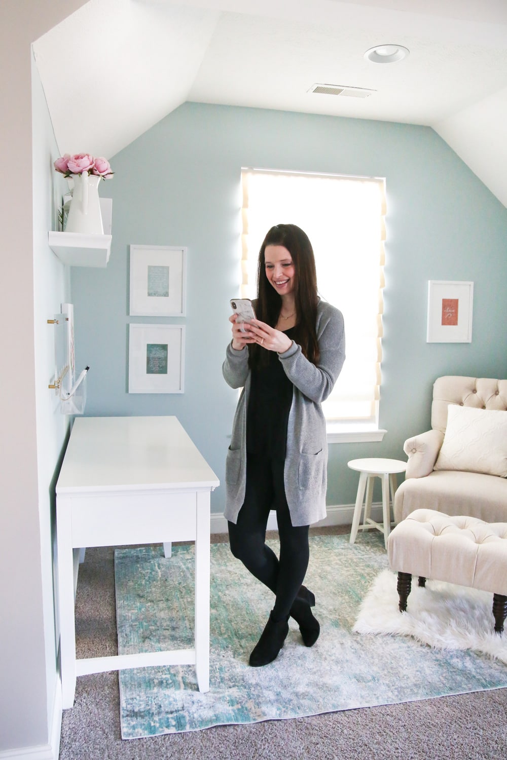 woman looking at Evernote on her phone in an organized home office