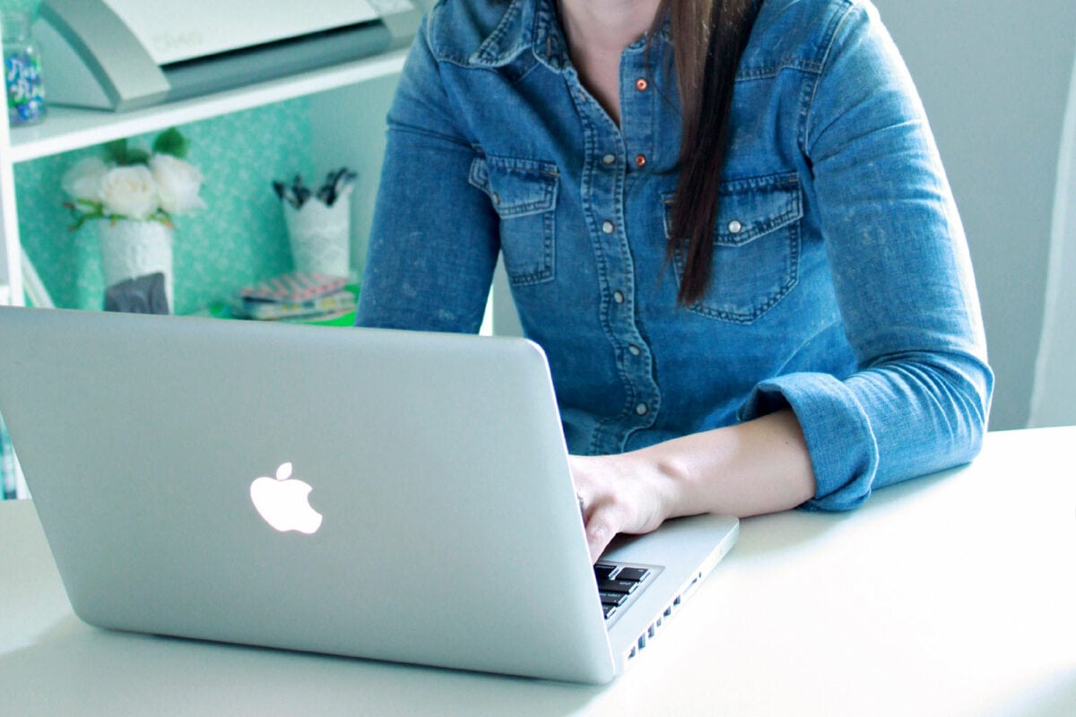 Woman typing on a laptop computer, using the debt snowball method to pay down debt