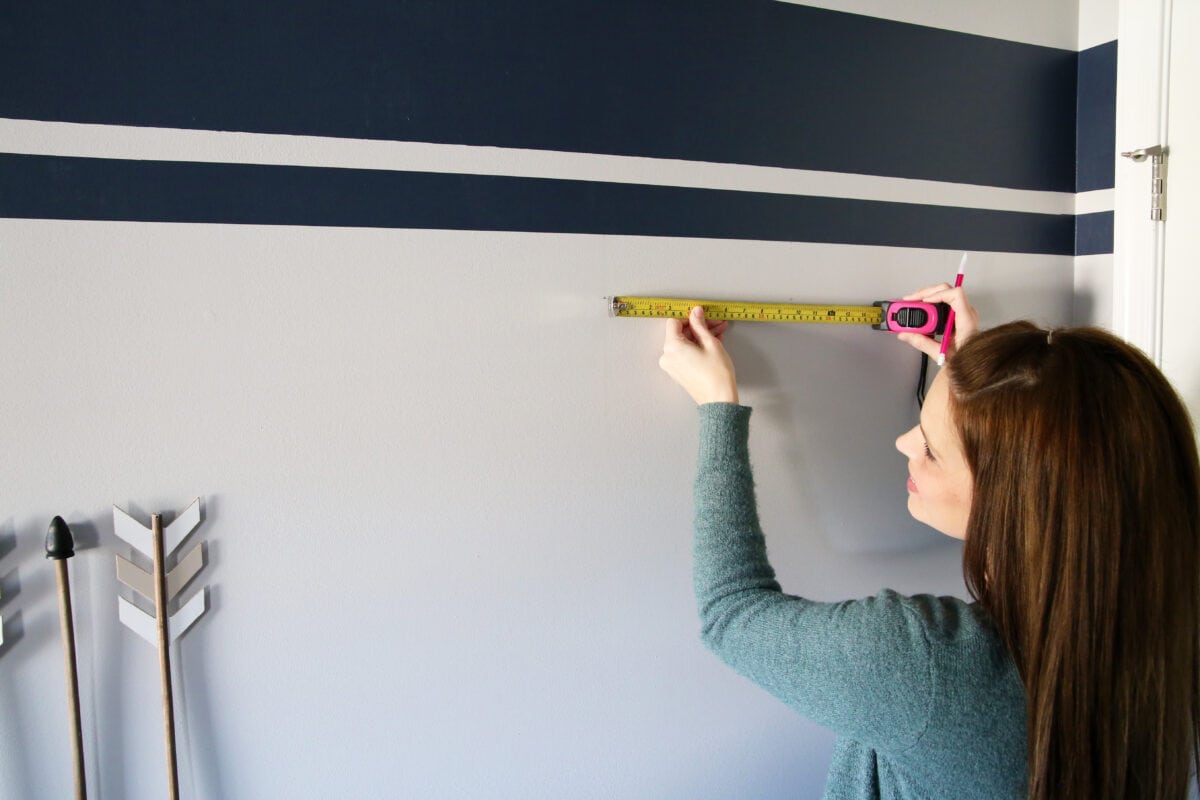 planning the layout of an organized hat wall using a measuring tape