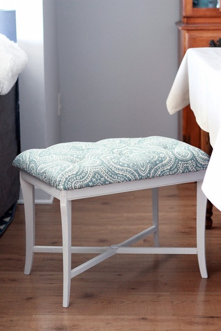 side view of the finished tufted bench with the bottom being white and the top being covered wtih fabric.