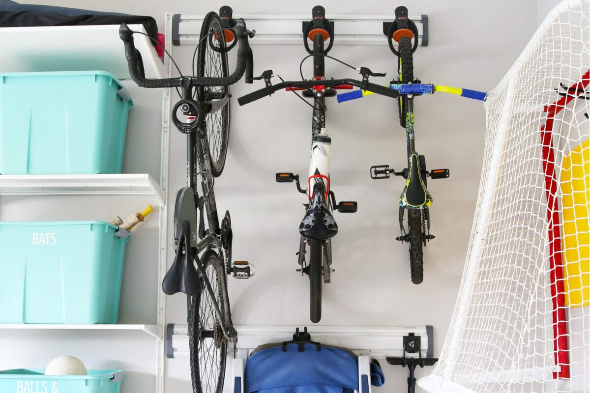 Three bikes hanging on a wall mounted rack in an organized garage