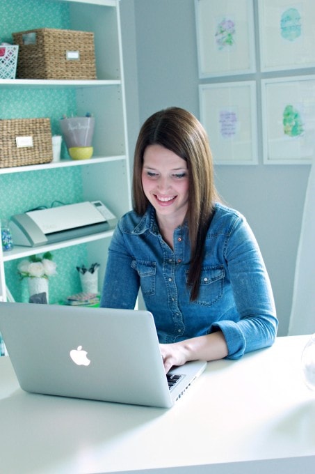 Woman in a chambray shirt looking at a laptop computer