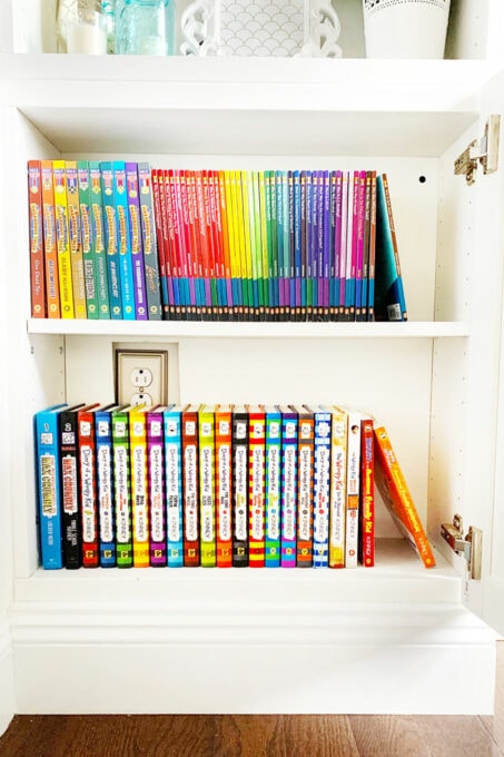 bright colored books in white cabinet