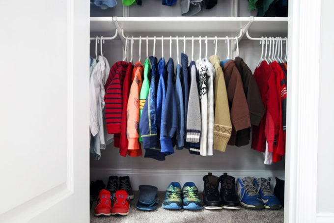 Child's clothes hanging in an organized closet on matching hangers