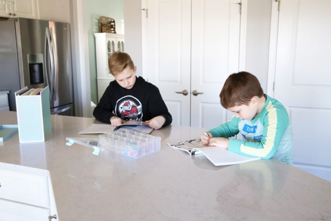 Boys Coloring at Kitchen Island, This simple portable, organized kids' art station makes it easy for kids to be creative anywhere in the house! | #artstation #artsupplies #organizedkids #organization #organized #organizedwithkids 