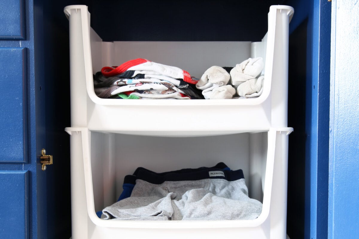 Kids' clothes stacked flat in an organized bedroom