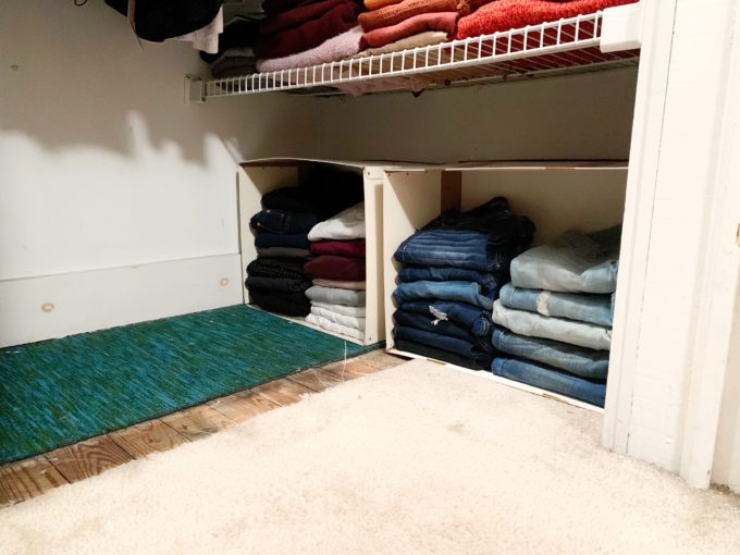 Jeans stacked and organized in upcycled bins in the bottom of a small closet