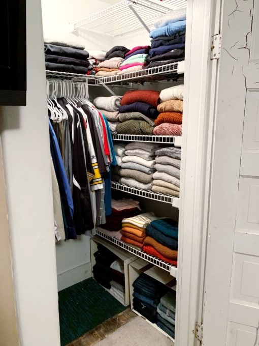 Folded sweaters stacked and organized in a closet on wire shelves