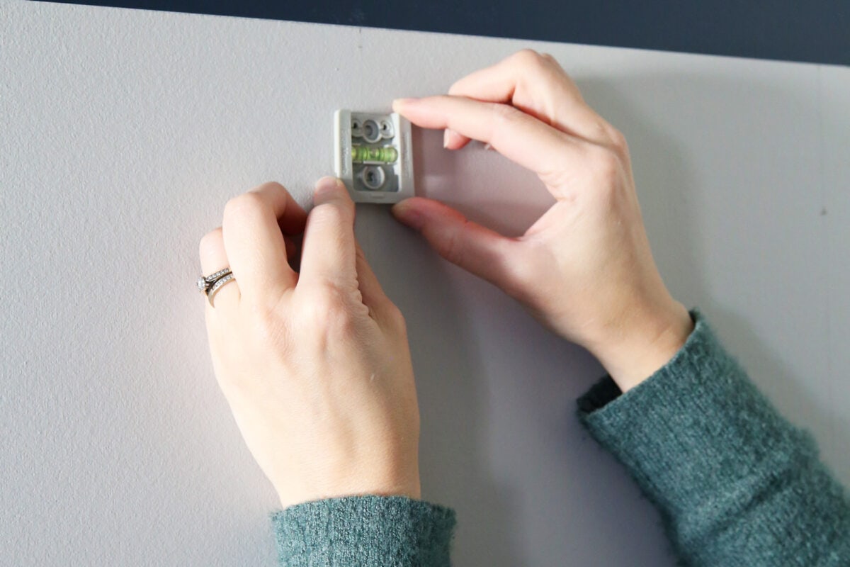 Attaching the J-hook base plate to the wall using the built-in level