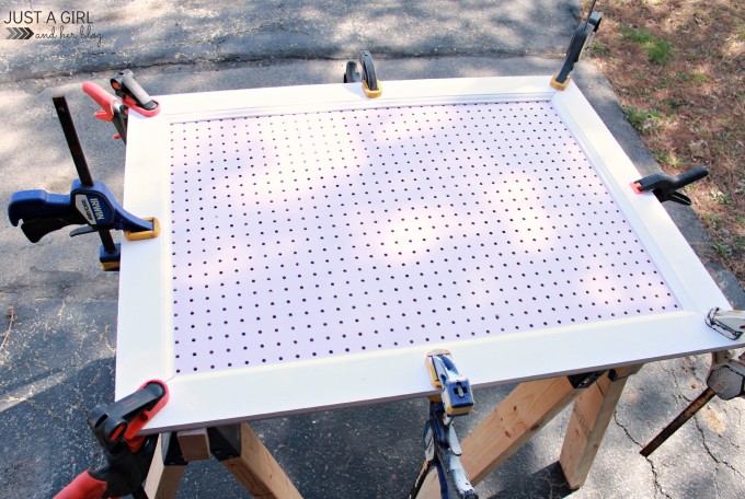 pegboard frame attached with wood glue with clamps holding the frame to the pegboard