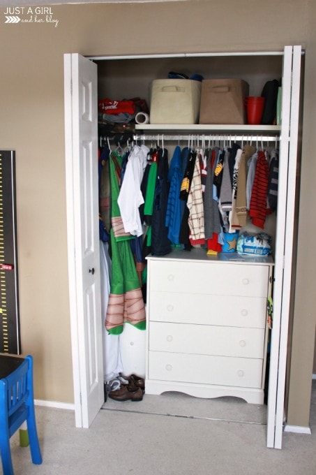 cluttered kids' closet with the doors open