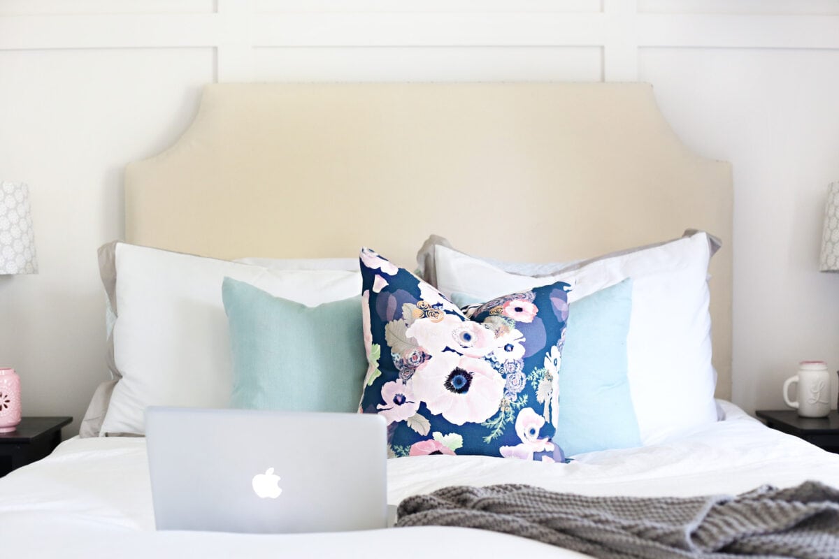 Laptop Computer Sitting on a Bed with a Floral Pillow