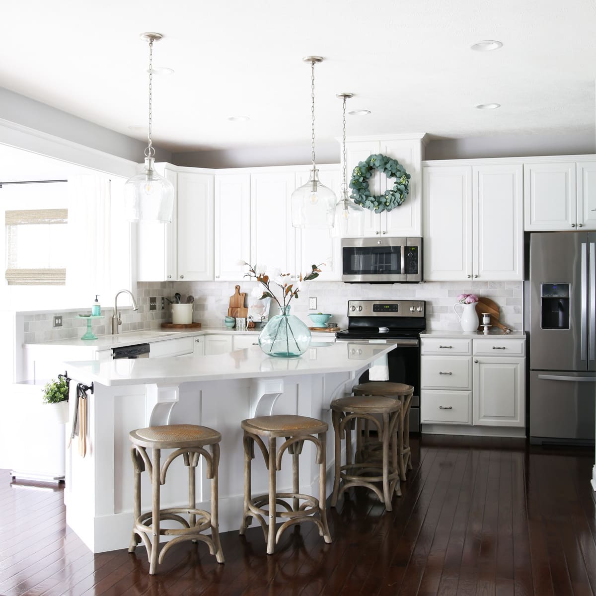 white kitchen with large island and wood floors