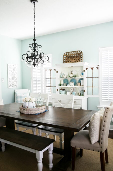 Dining room with aqua walls and white hutch with fall decor, part of a whole house "uniform"