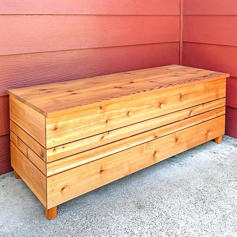 DIY outdoor storage box sitting in front of a red wall