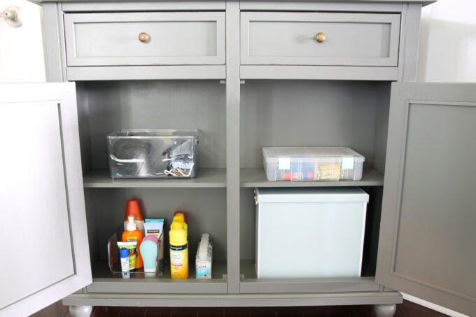 Organized Entryway Cabinet Holding Sunscreen, Bug Spray, Hand Sanitizer, Masks, and Kids' Art Supplies