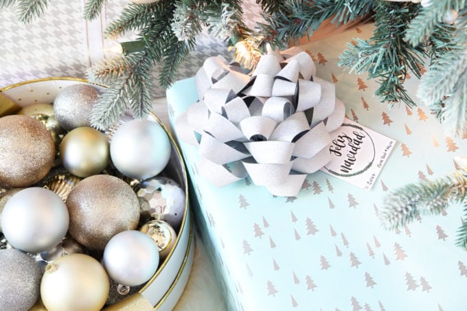 a light blue wrapped present with a white bow and a Feliz Navidad tag