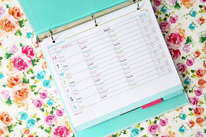 Free printable health and fitness tracker clipped into an organized binder