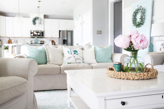 Flowers on Coffee Table, Couch with Pillows, White Kitchen