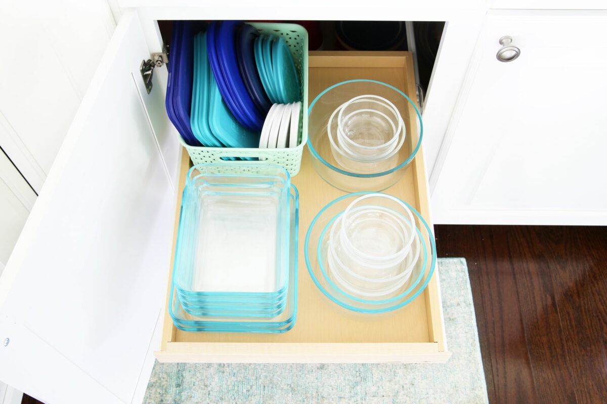 Organized food storage containers in a kitchen cabinet