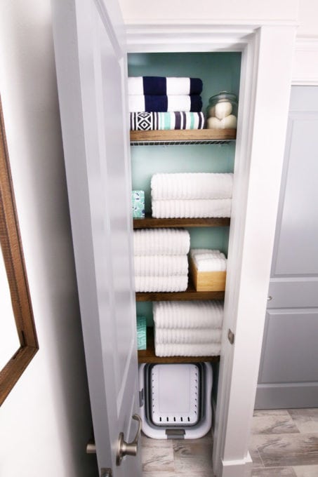 Organized Linen Closet with Wood Shelf Covers Over Wire Shelves