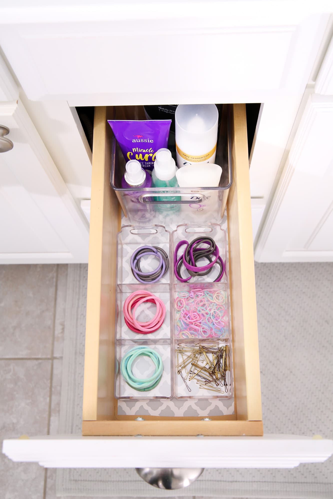 Bathroom vanity drawer with hair supplies in bins