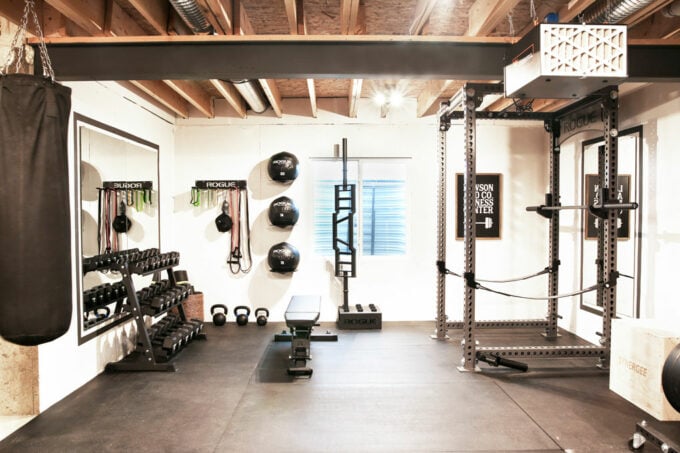 Basement Home Gym with Dumbells, Medicine Balls, a Weightlifting Rack, and a Punching Bag