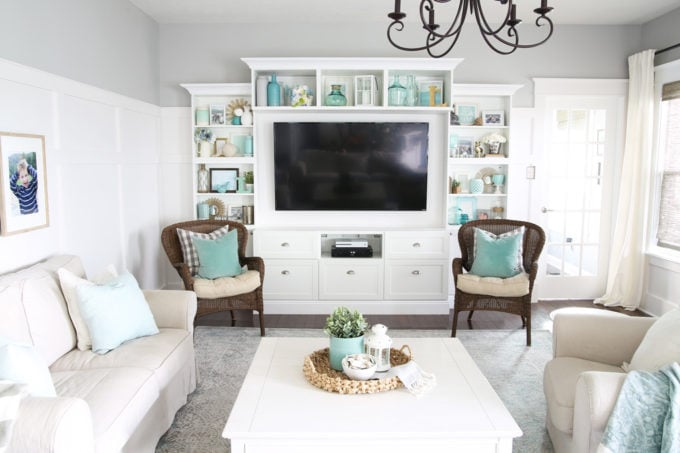 White, Neutral, and Aqua Living Room with a Large Entertainment Unit that Has Beautifully Styled and Decorated Shelves