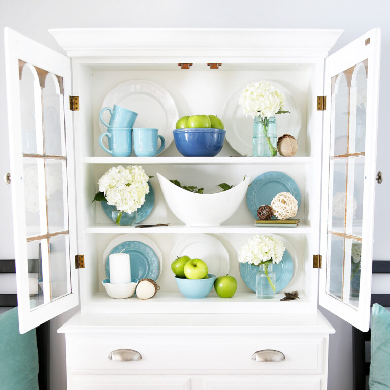 Hutch painted white and decorated with aqua and white tchotchkes