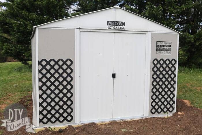 White, gray, and black shed with metal lattice