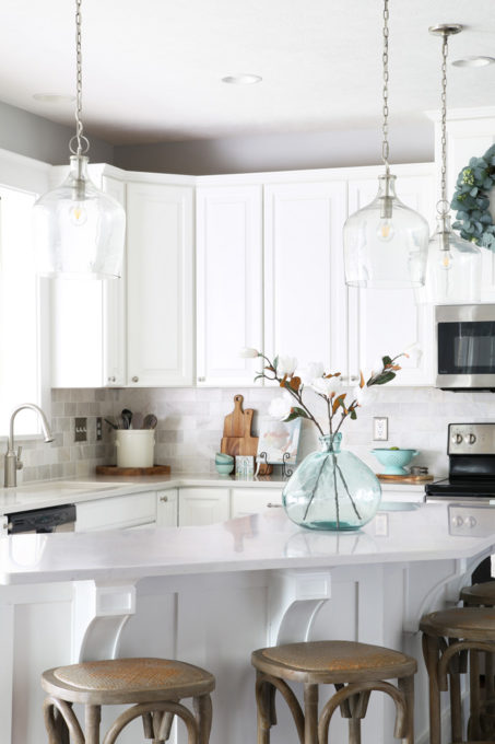 White Kitchen with Clear Pendant Lights Over the Island in a Ryan Homes Palermo