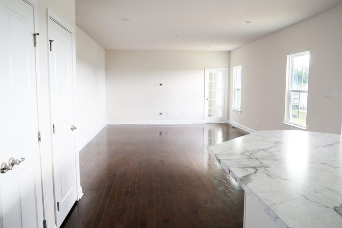 a living room and kitchen with dark hardwood floors