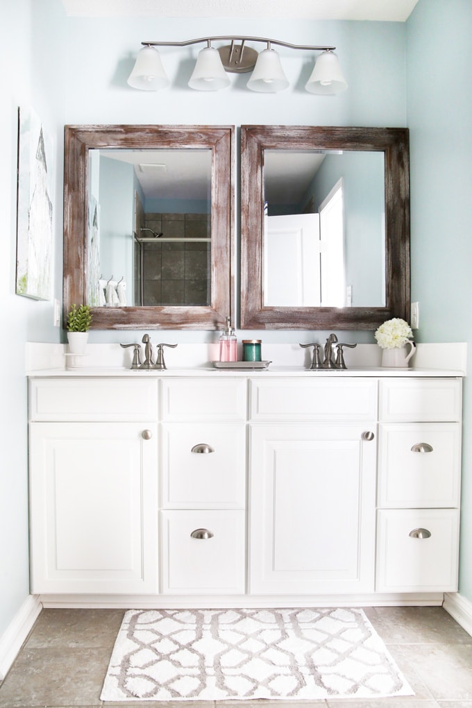 I'm sharing all of my favorite master bathroom organization ideas and some easy updates that we've done to take our master bathroom from cluttered and boring to organized and beautiful! | bathroom organization, organized bathroom vanity, how to organize a bathroom, how to organize deep vanity drawers, organized hair supplies, shaving tools organization, change out builder grade mirrors for wooden framed mirrors