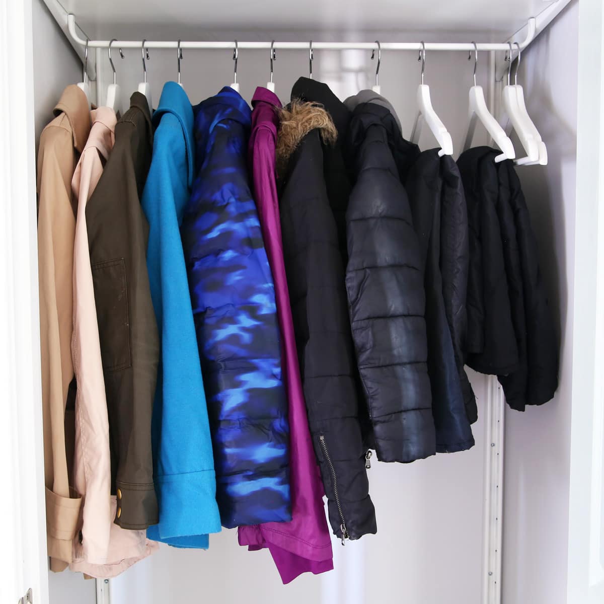 Coats and snow pants hanging in an organized entry closet