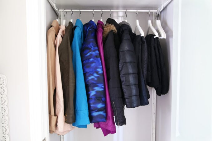 Organized coat closet with matching white wood hangers, closet ideas