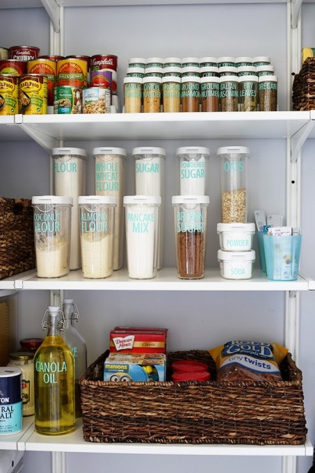 all of the labeled pantry items back on the shelves with other baskets