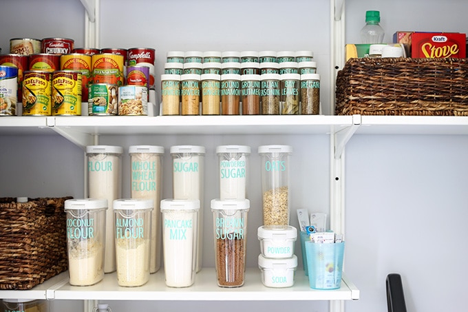 Spices and cans on risers in an organized kitchen pantry