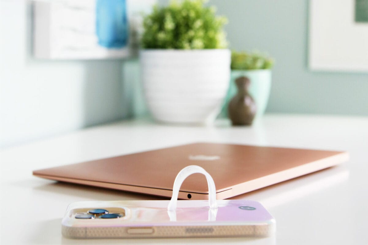 A desk with a laptop computer and an iphone