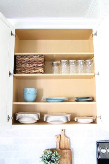 Organized Kitchen Cabinet with Plates, Bowls, and Mason Jars