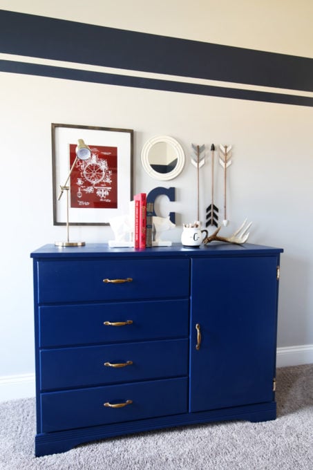 a navy blue dresser with gold hardware