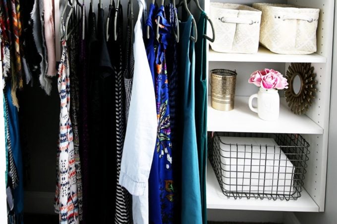 Bed sheets in wire bin in an organized primary closet