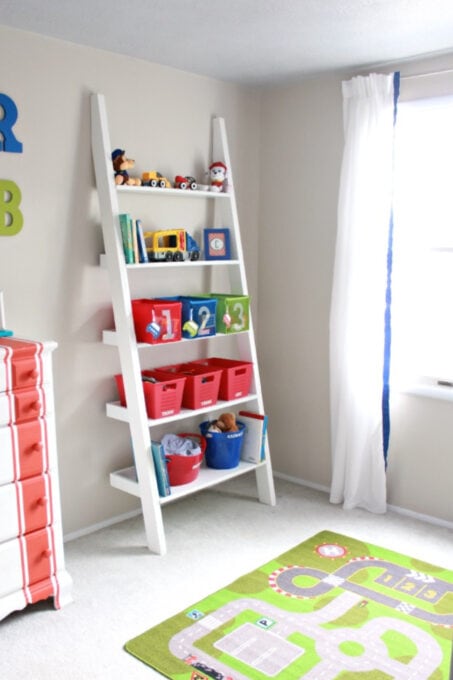 Leaning ladder shelf with kids' toys on it