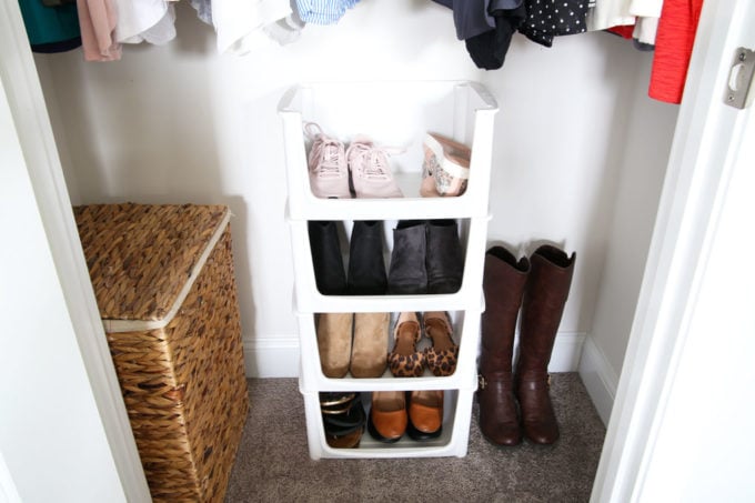 Shoes organized in stacking pantry bins within a small closet