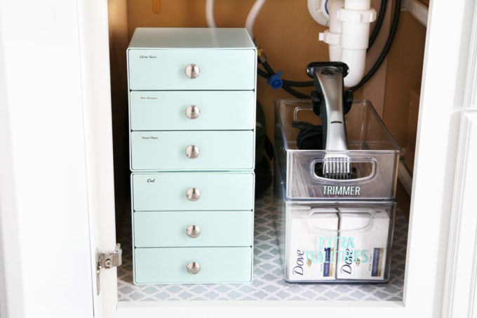 under the bathroom sink organized with bins