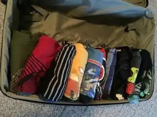 Clothes folded in stacks in a suitcase